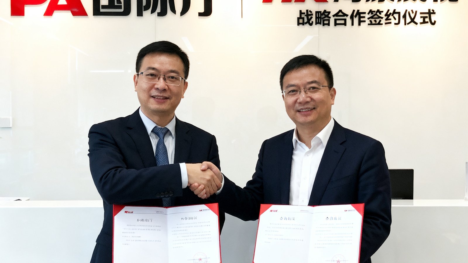 PA国际厅与海康威视战略合作签约仪式现场照片，双方代表握手并展示合作协议文件，背景是两家公司的品牌墙。